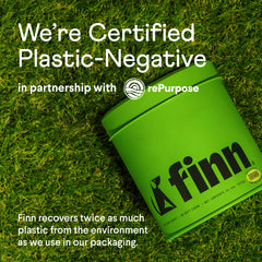 Green Finn chewing tobacco container on grass background with "We're Certified Plastic-Negative" sustainability messaging