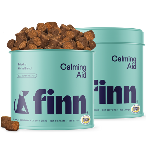 Two turquoise Finn pet supplement cans labeled "Calming Aid" with brown beef liver flavored chews scattered around them