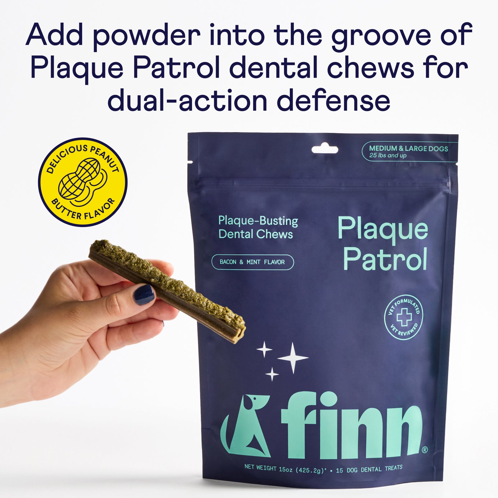 Hand holding a dental chew stick with green powder coating next to blue Finn Plaque Patrol package for medium and large dogs