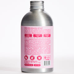 Silver aluminum bottle with pink label showing dog shampoo product information and ingredients on back panel