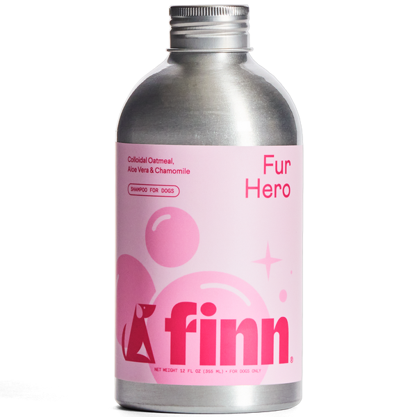 Silver aluminum bottle of Finn Fur Hero dog shampoo with pink label featuring colloidal oatmeal, aloe vera and chamomile