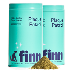 Two turquoise containers of Finn Plaque Patrol dental powder for dogs with a pile of brown powder in front