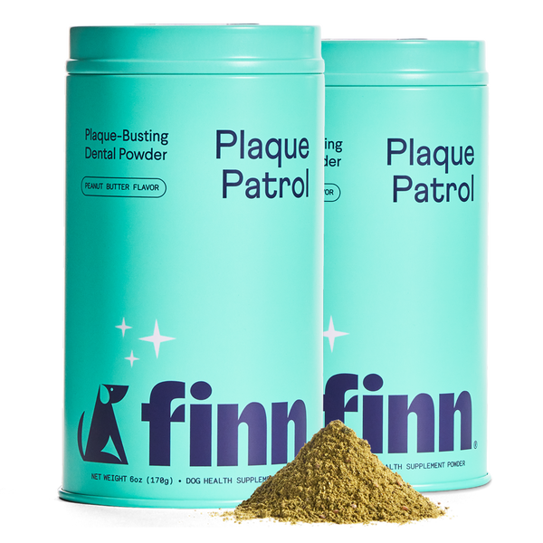 Two turquoise containers of Finn Plaque Patrol dental powder for dogs with a pile of brown powder in front