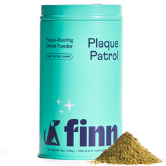 Turquoise cylindrical tin labeled "Plaque Patrol" dental powder for dogs with peanut butter flavor, pile of brown powder beside it