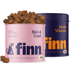 Two Finn dog supplement containers - pink "Skin & Coat" with beef liver chews spilling out and blue "Multi Vitamin" canister