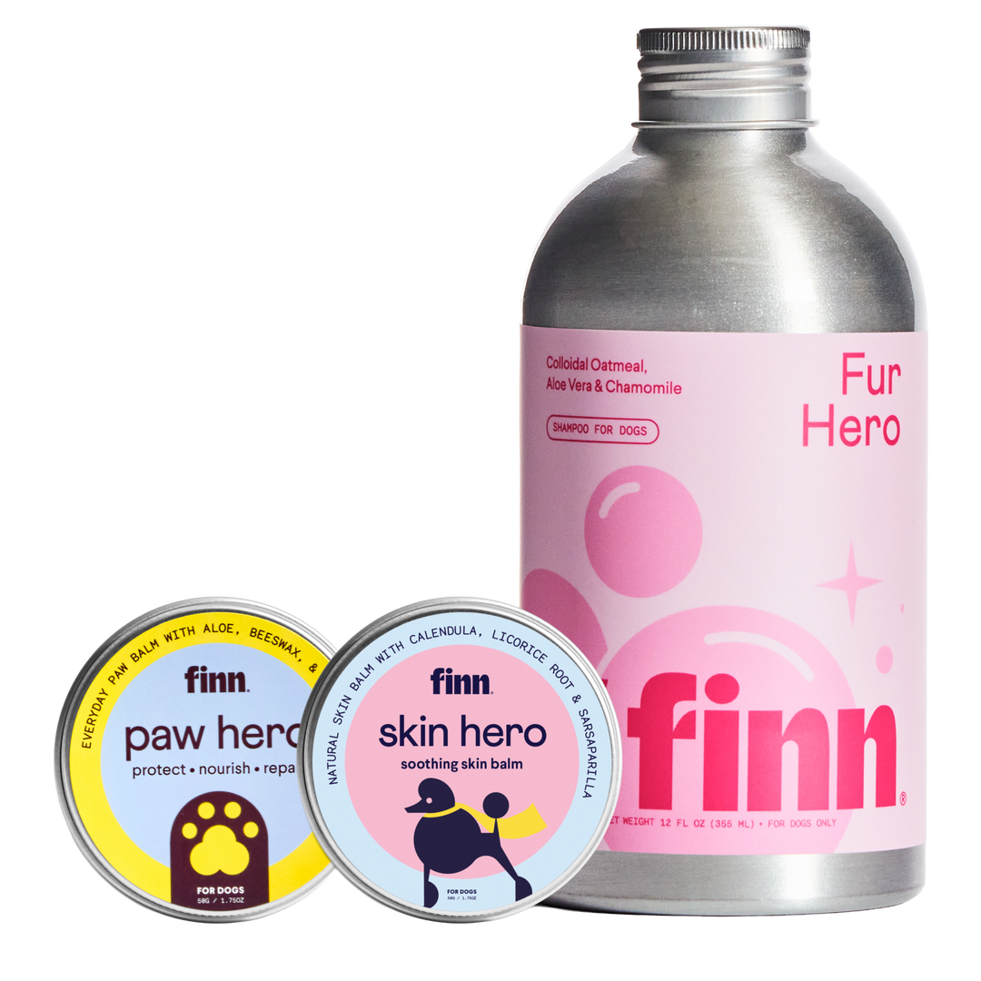 Dog grooming products: pink Finn Fur Hero shampoo bottle and two circular tins of Finn paw hero and skin hero balms