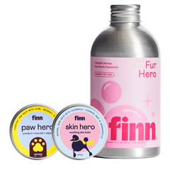 Dog grooming products: pink Finn Fur Hero shampoo bottle and two circular tins of Finn paw hero and skin hero balms