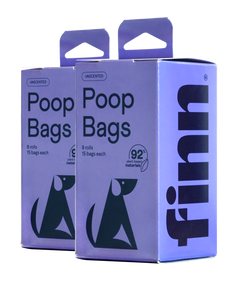 Two purple boxes of unscented poop bags, each containing 8 rolls with 15 bags, featuring green dog silhouettes and made from 92% plant-based materials.