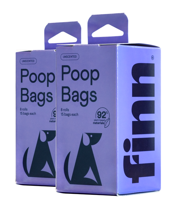 Two purple boxes of unscented poop bags, each containing 8 rolls with 15 bags, featuring green dog silhouettes and made from 92% plant-based materials.