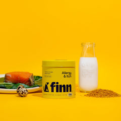 Yellow Finn Allergy & Itch supplement container with milk bottle, salmon, quail egg, and kibble on yellow background