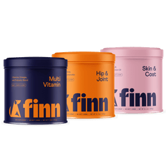 Three colorful Finn dog supplement containers in navy blue, orange, and pink, labeled Multi Vitamin, Hip & Joint, and Skin & Coat